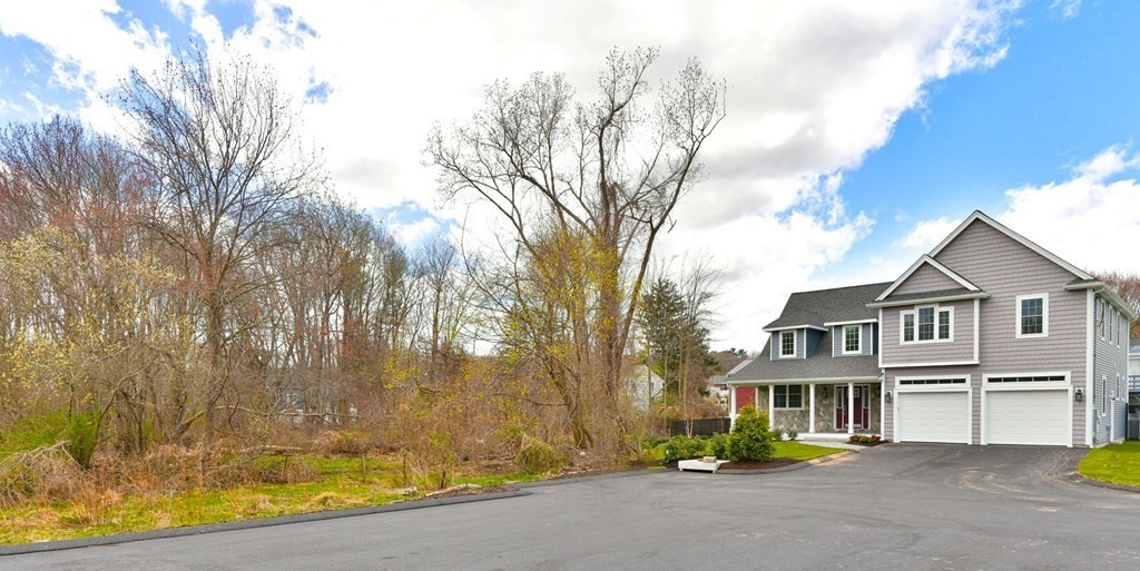 35 Roosevelt Road Dedham, MA 02026 - Photo 8 of 40 a view of a white house with a large tree and wooden fence