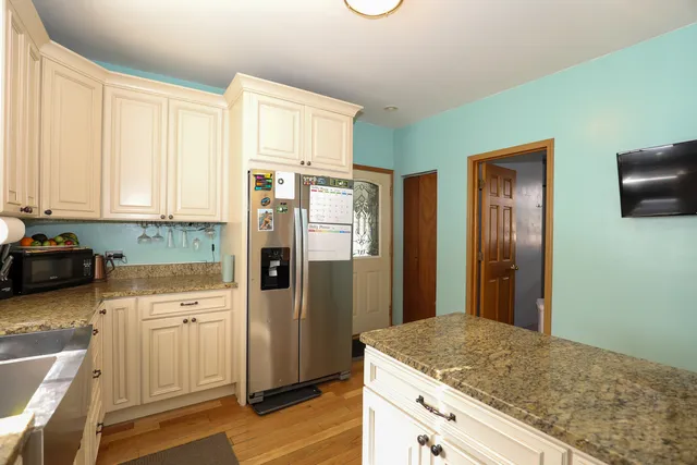 a kitchen with stainless steel appliances granite countertop a refrigerator and cabinets