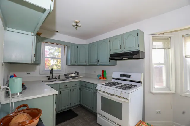 a kitchen with a sink a stove and cabinets