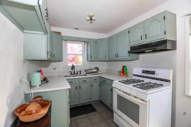 a kitchen with stainless steel appliances granite countertop a sink stove and cabinets