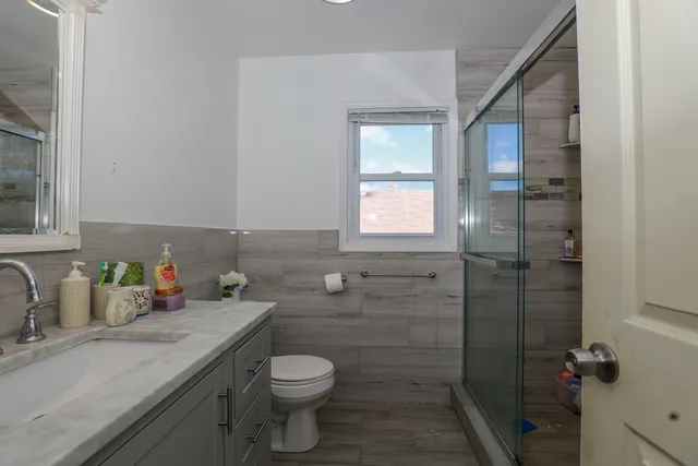 a bathroom with a sink a toilet and shower