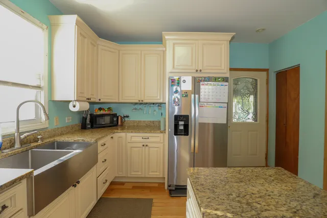 a kitchen with a refrigerator sink and cabinets
