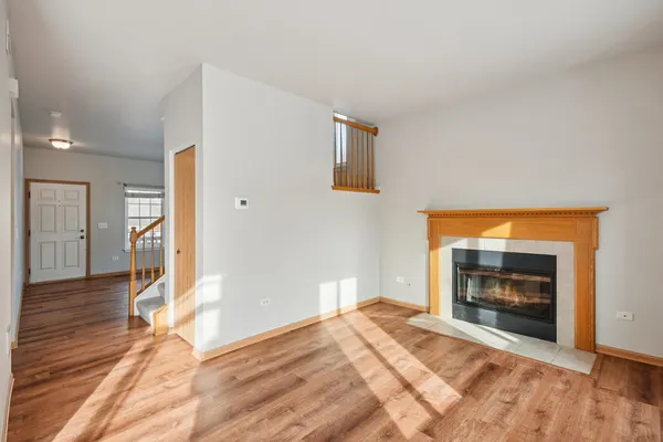 a view of an empty room with a window and fireplace