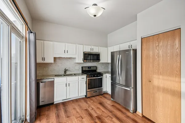 a kitchen with stainless steel appliances a refrigerator sink and microwave