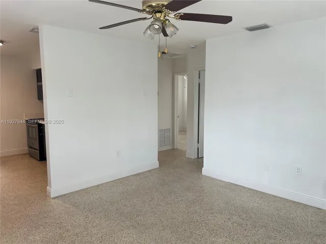 an empty room and chandelier fan