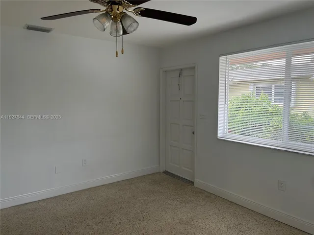 a view of a room with a window and a fan