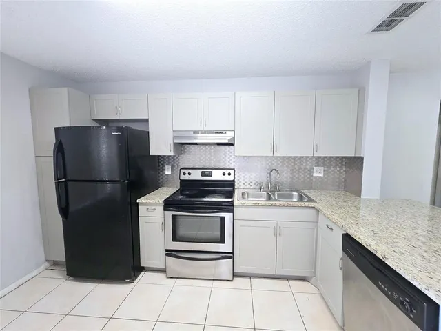a kitchen with a sink stove and refrigerator