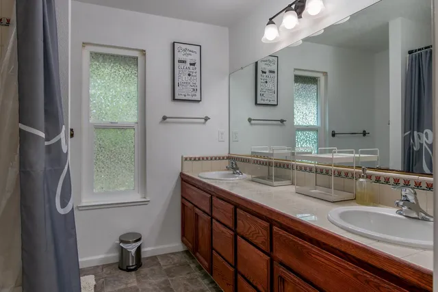 a bathroom with a granite countertop sink and a mirror
