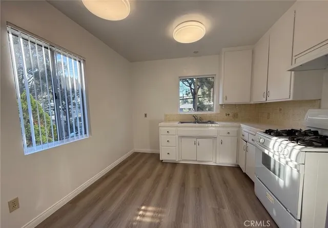 a kitchen with a white stove top oven sink and cabinets