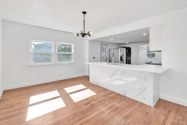 a view of a kitchen with wooden floor and a window