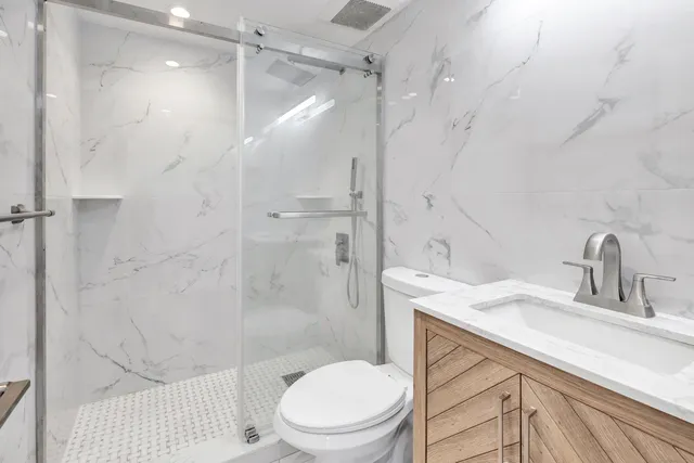 a bathroom with a sink a toilet and shower