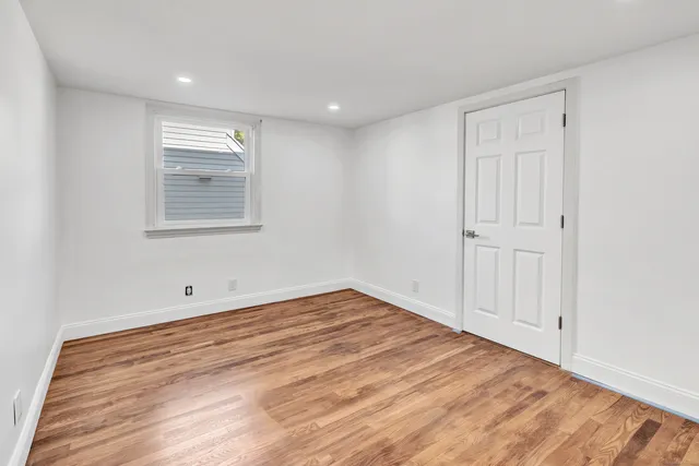 a view of empty room with wooden floor