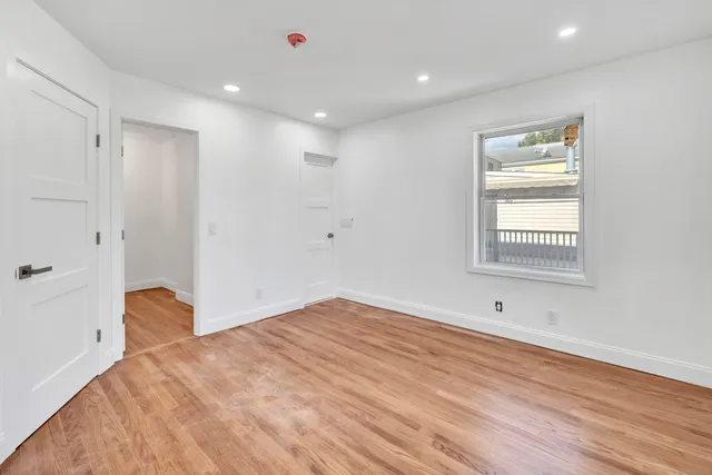 a view of empty room with wooden floor