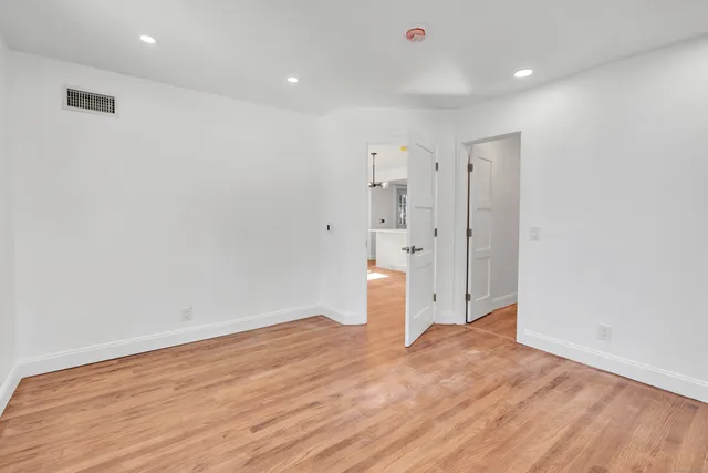 a view of empty room with wooden floor