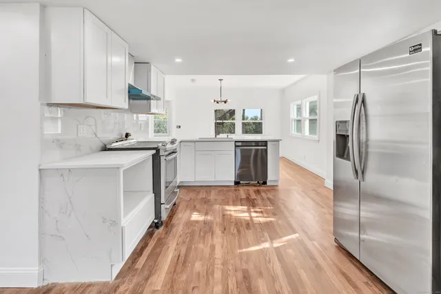 a kitchen with a sink refrigerator and cabinets