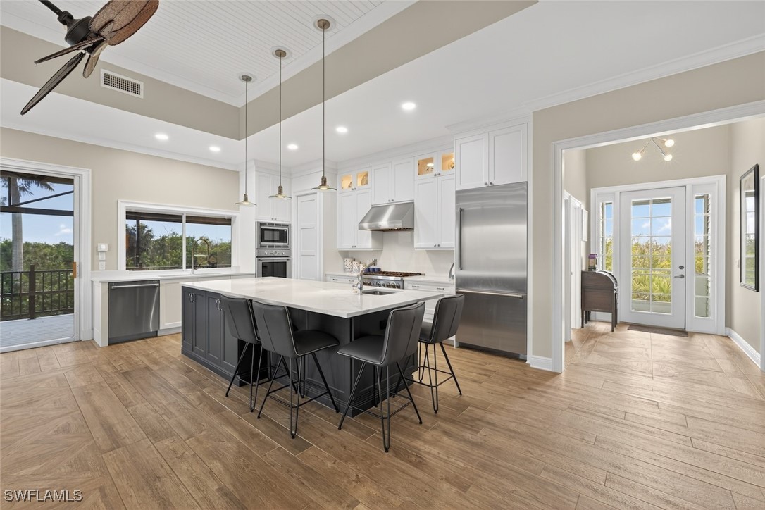 1537 Sand Castle Road Sanibel, FL 33957 - Photo 9 of 50 a kitchen with stainless steel appliances kitchen island granite countertop a table chairs and a refrigerator