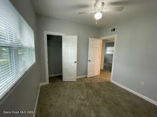 an empty room with windows and fan