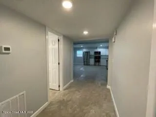 an empty room with windows and refrigerator