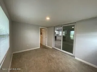 an empty room with closet and a ceiling fan