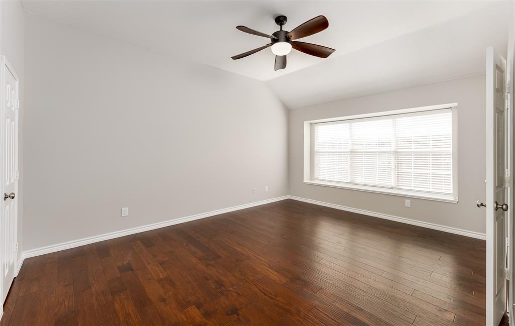9507 Landmark Place Frisco, TX 75035 - Photo 13 of 18 an empty room with wooden floor ceiling fan and windows
