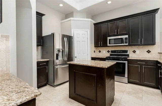 a kitchen with kitchen island granite countertop stainless steel appliances and stove