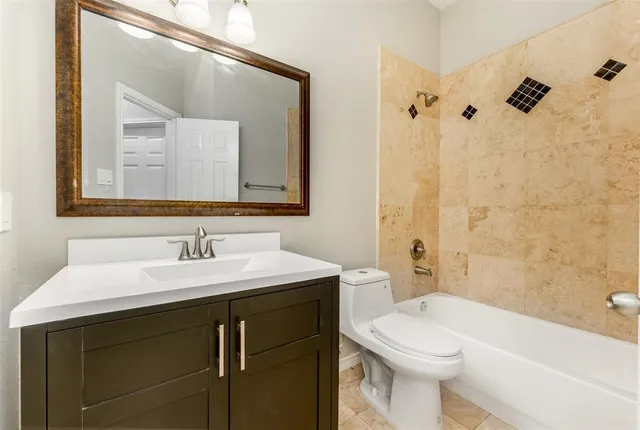 a bathroom with a toilet a sink a bath tub and mirror