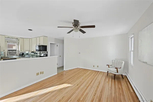 a view of a kitchen with wooden floor and a ceiling fan