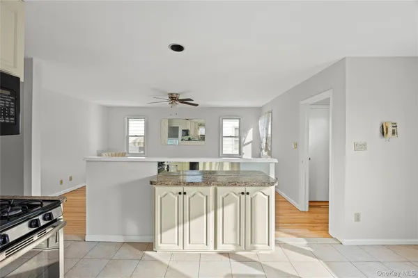a kitchen with kitchen island sink stove and cabinets
