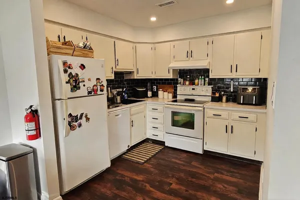 a kitchen with white cabinets and white appliances