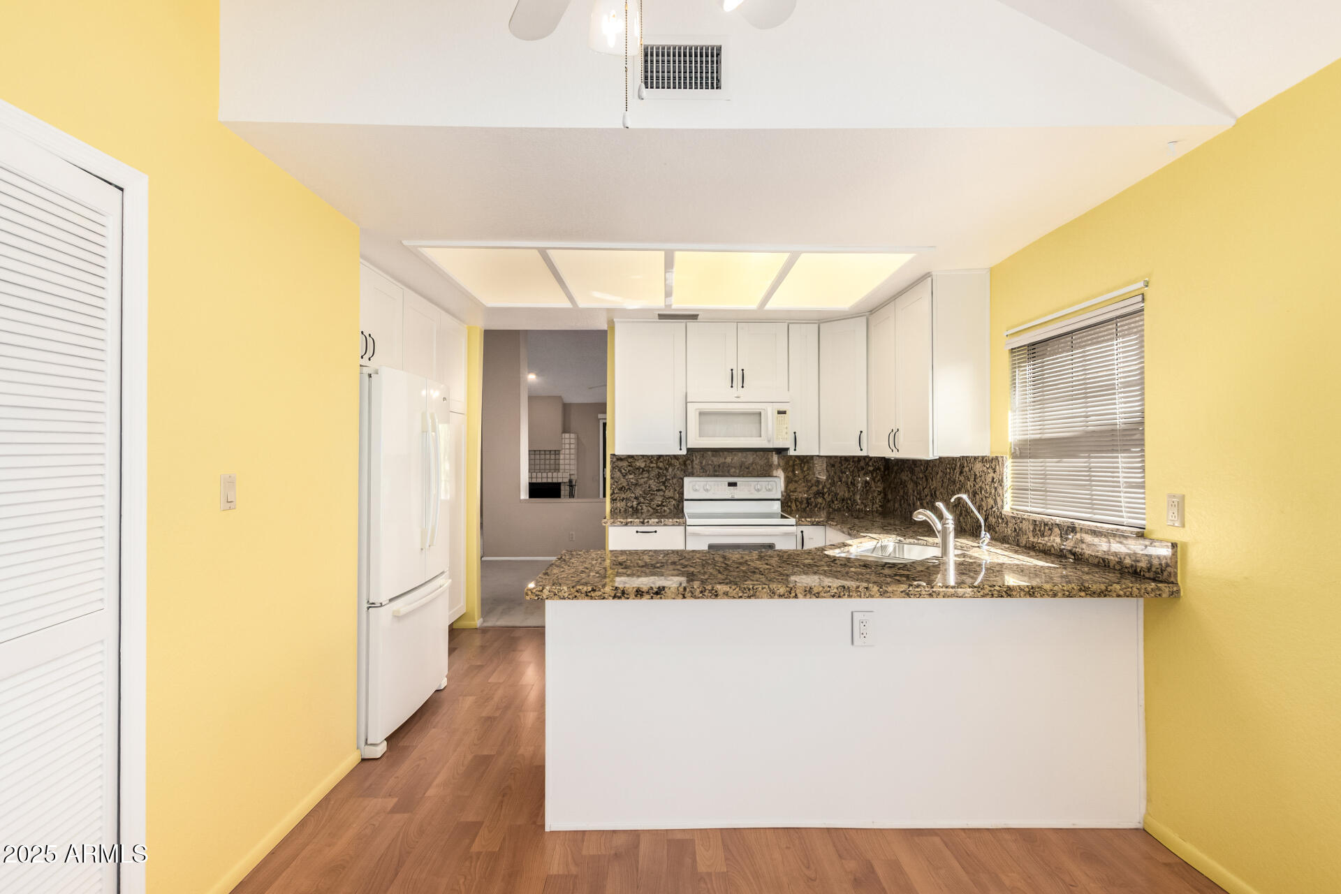 10019 East Mountain View Road, Unit 2114 Scottsdale, AZ 85258 - Photo 10 of 40 a view of a kitchen with kitchen island a sink wooden floor and a counter top space
