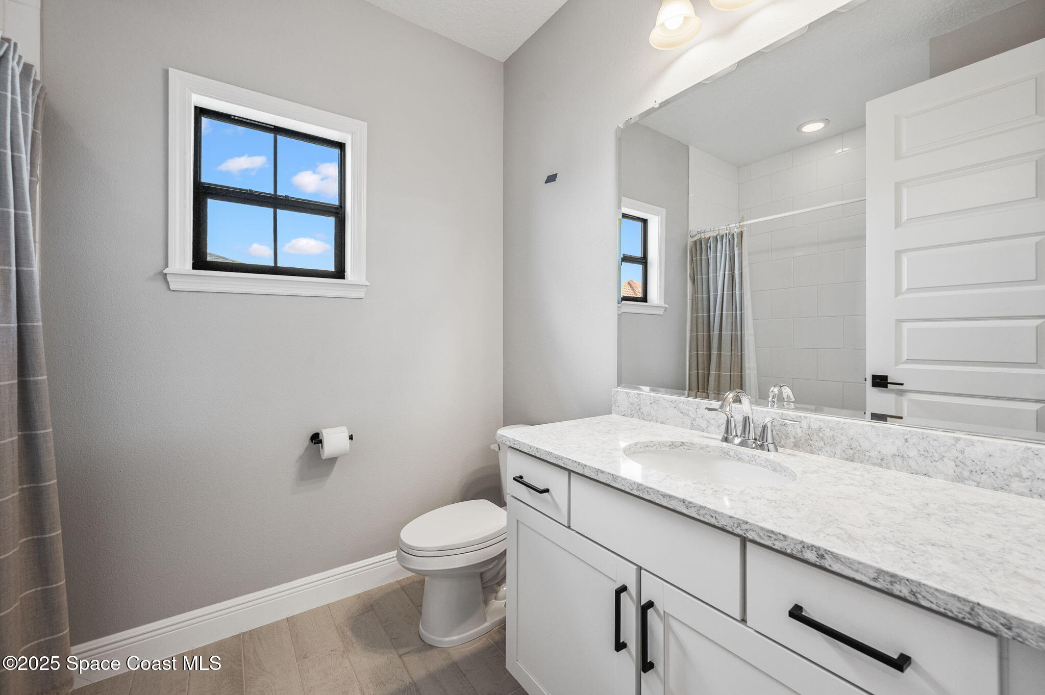 2444 Addison Drive Melbourne, FL 32940 - Photo 40 of 93 a bathroom with a granite countertop toilet sink and mirror