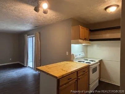 a kitchen with a stove and a wooden floor