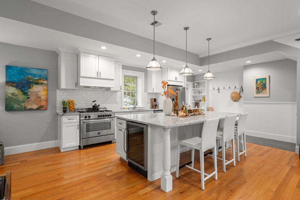 165 Park Avenue, Unit 165 Arlington, MA 02476 - Photo 10 of 32 a kitchen with stainless steel appliances granite countertop a stove a sink a refrigerator dining table and chairs with wooden floor