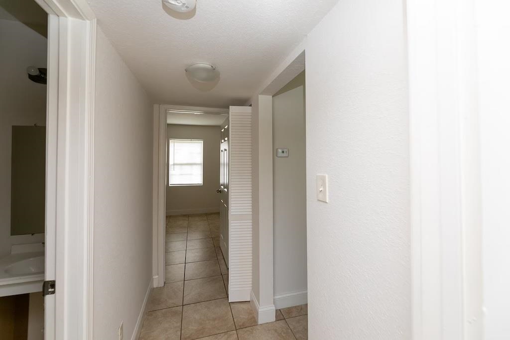 3236 Millington Road Memphis, TN 38127 - Photo 15 of 31 Interior hallway featuring tile flooring, white painted walls, and overhead lighting fixtures