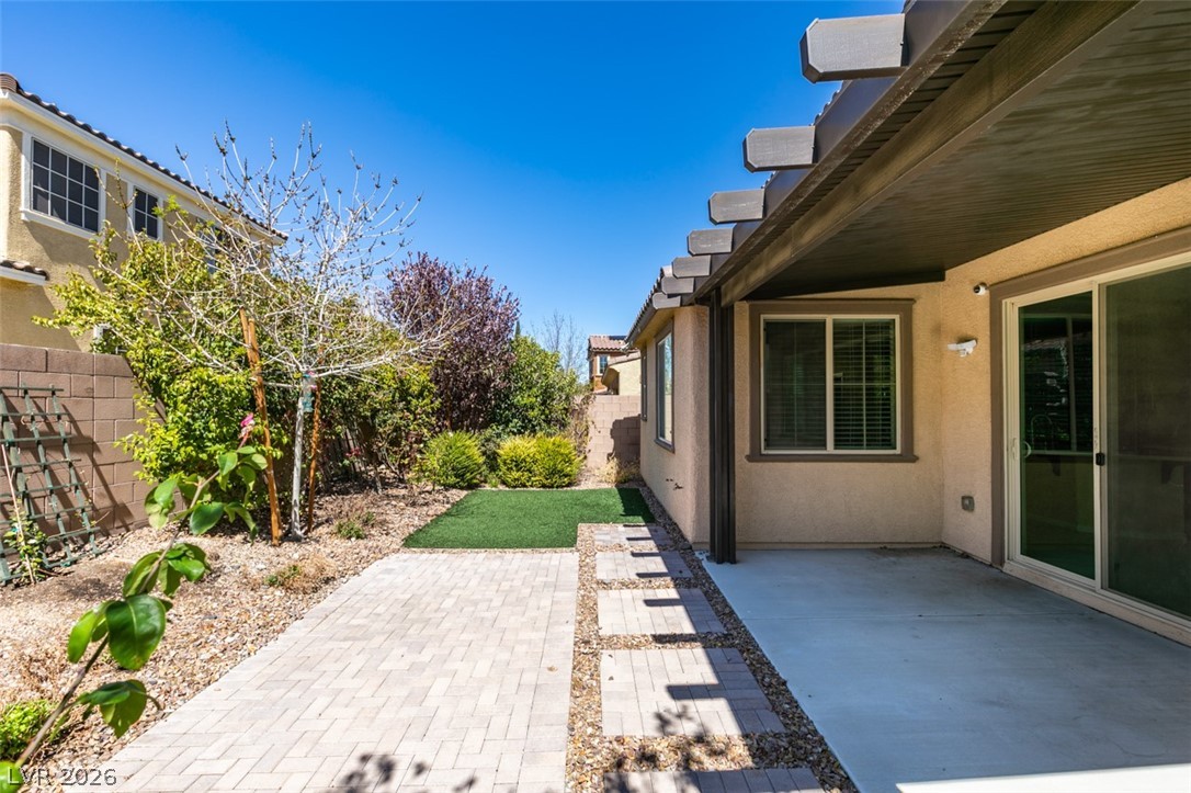 2549 Sable Ridge Street Henderson, NV 89044 - Photo 5 of 8 A private, sun-drenched backyard awaits, complete with a covered patio and verdant landscaping.