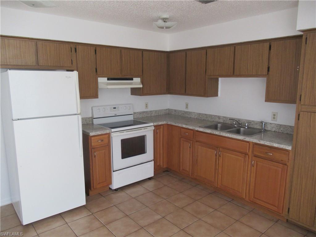 7461 Pebble Beach Road Fort Myers, FL 33967 - Photo 4 of 11 a kitchen with cabinets appliances and a sink