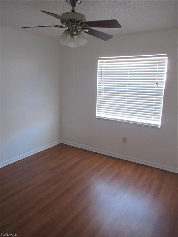7461 Pebble Beach Road Fort Myers, FL 33967 - Photo 6 of 11 an empty room with wooden floor fan and windows