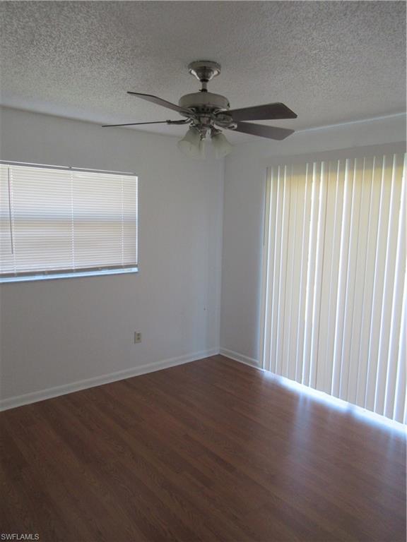 7461 Pebble Beach Road Fort Myers, FL 33967 - Photo 7 of 11 an empty room with wooden floor fan and windows