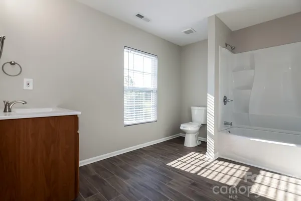 a bathroom with a sink toilet a bathtub and next to a window