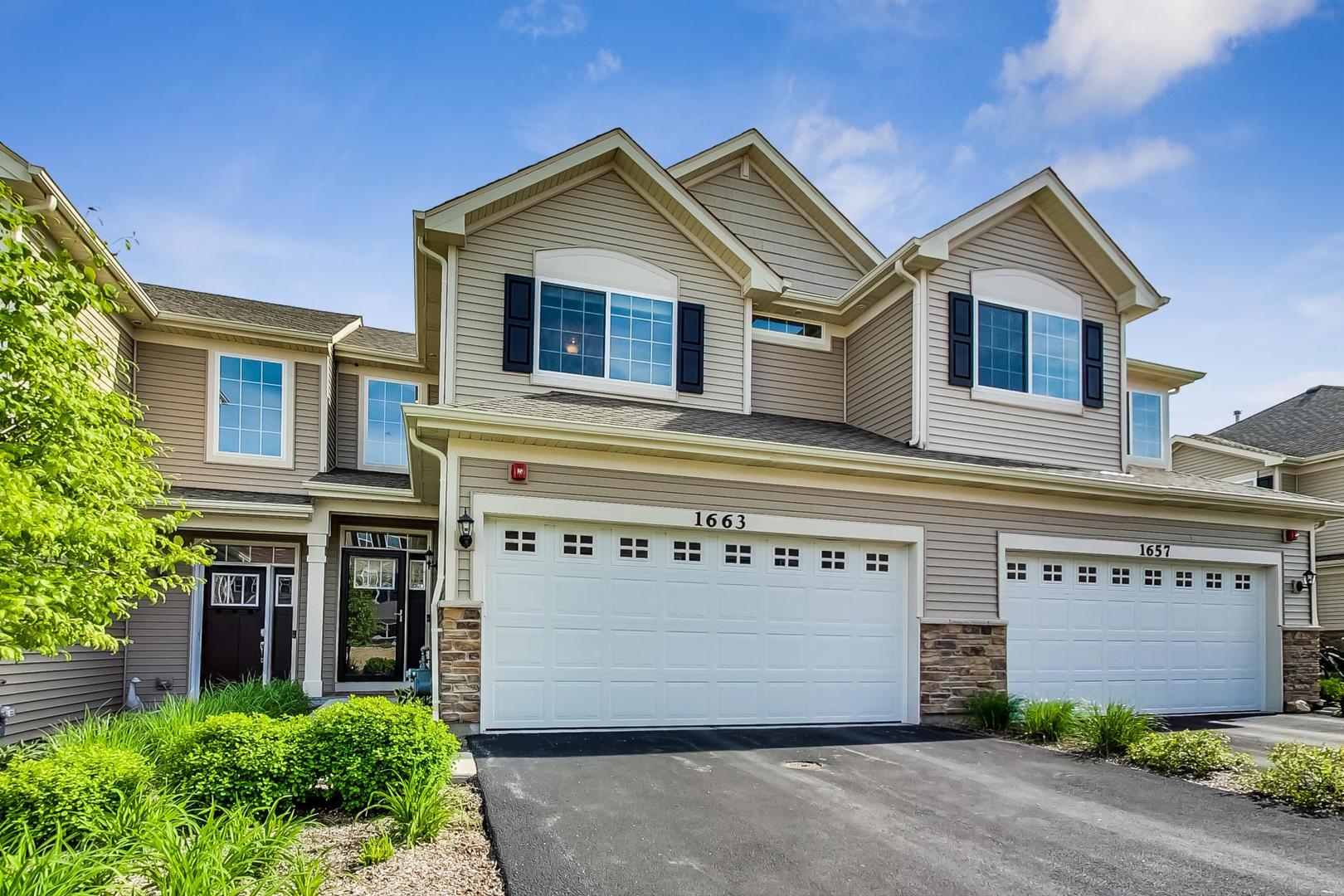 a view of a house with a garage and yard