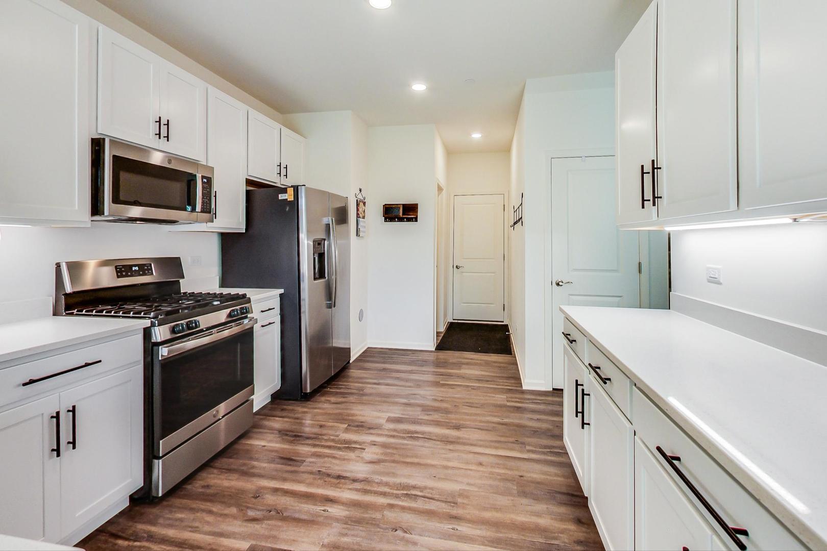 1663 Kraft Avenue Batavia, IL 60510 - Photo 12 of 47 a kitchen with white cabinets stainless steel appliances and sink