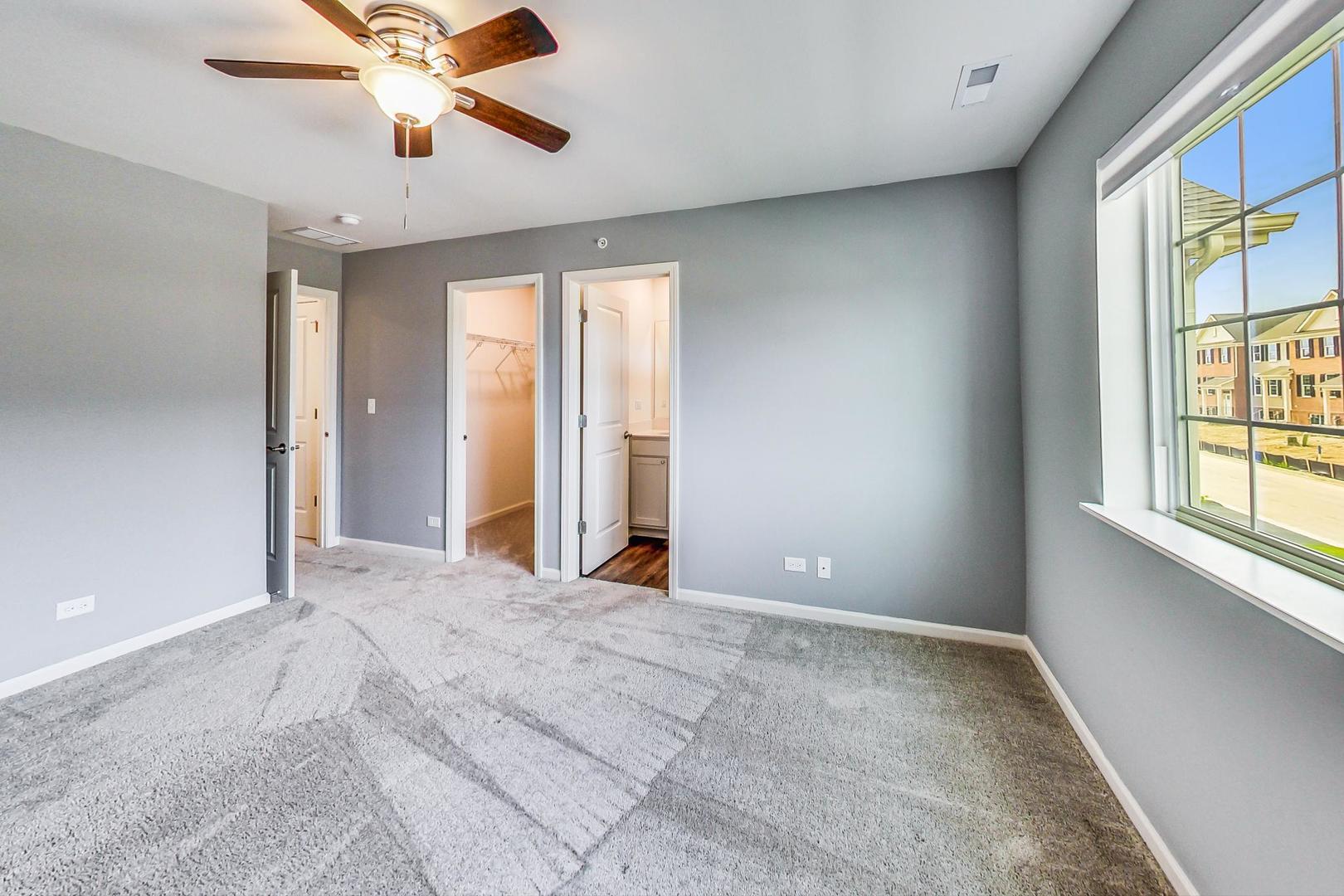 1663 Kraft Avenue Batavia, IL 60510 - Photo 18 of 47 an empty room with windows and chandelier fan