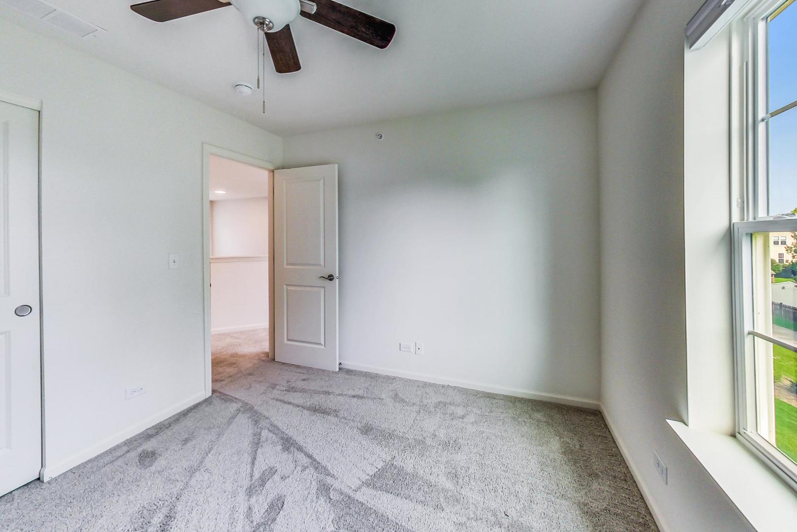 1663 Kraft Avenue Batavia, IL 60510 - Photo 26 of 47 an empty room with windows and chandelier fan