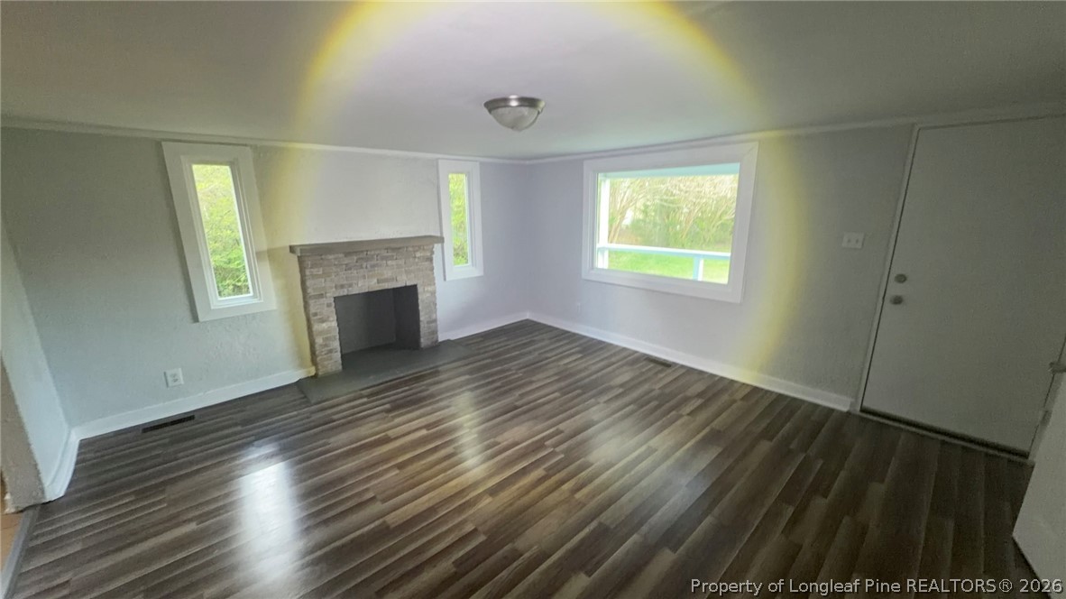 3612 Mt Zion Church Road Mebane, NC 27302 - Photo 14 of 37 an empty room with wooden floor fireplace and windows