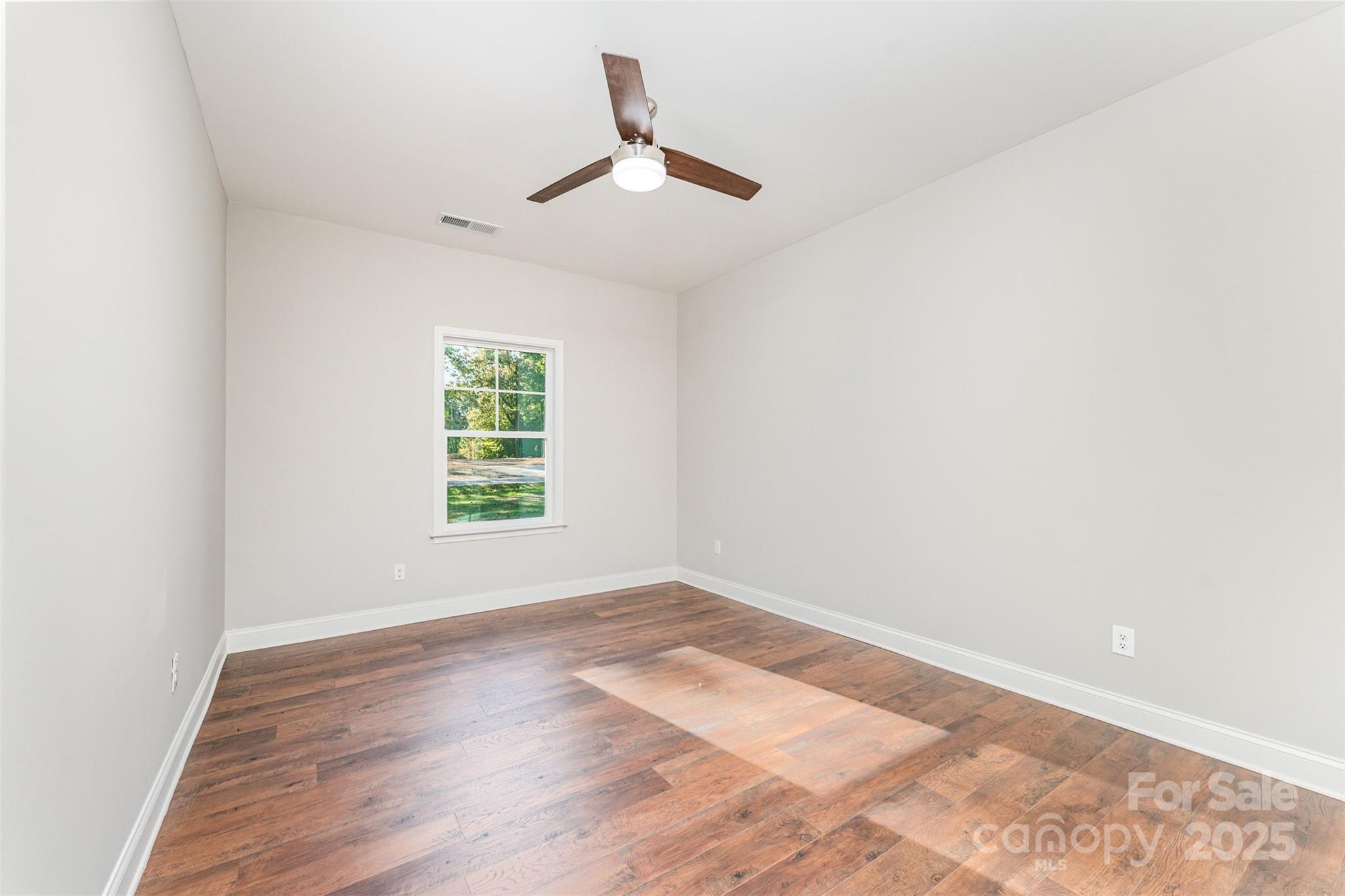 839 Stanley Spencer Mountain Road Gastonia, NC 28056 - Photo 21 of 26 a view of empty room with wooden floor and fan