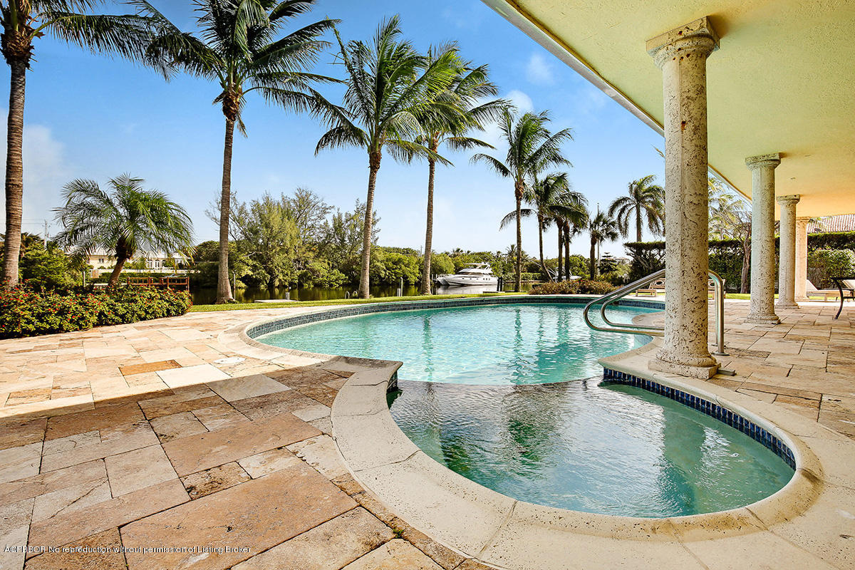 1 Spoonbill Road Manalapan, FL 33462 - Photo 22 of 28 a view of a swimming pool with a table and chairs