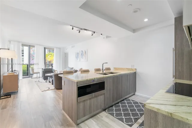 a view of kitchen with sink microwave and cabinets