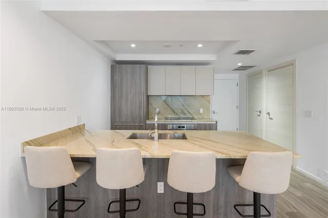 a kitchen with a dining table chairs and sink
