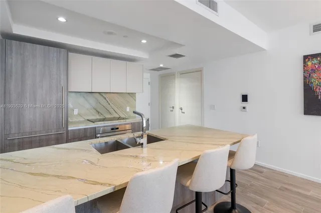 a kitchen with a table chairs and wooden floor