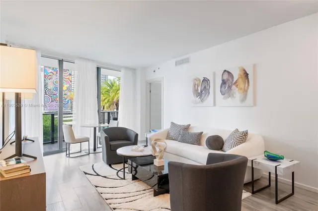 a living room with furniture and floor to ceiling windows